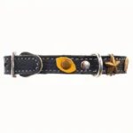 Linkerzij‑aanzicht van de elegante zwarte leren kattenhalsband “Guardian Eyes”, met gele kattenogen, messing sterren, elastische veiligheidssluiting en comfortlaag voor een stijlvolle, zelfverzekerde uitstraling.