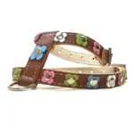 Harnais en cuir brun orné de fleurs pastel colorées en rose, bleu, vert et blanc avec centres métalliques, vu du côté droit.