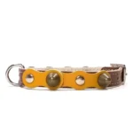 Collar pequeño de cuero marrón con capa amarilla brillante, tachuelas plateadas planas y picos redondeados de latón del diseño “Sunny Joy”. Ideal para perros alegres como Chihuahuas, Pomeranias y Caniches Enanos.
