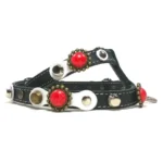 Harnais en cuir noir avec pierres corail, accents en laiton et couture blanche, vu du côté gauche.