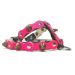 Black leather dog harness with a bold fuchsia top layer, decorated with alternating rounded studs and sharp metal spikes, shown from the left side. The layered leather and polished hardware create a glamorous, high‑impact look.