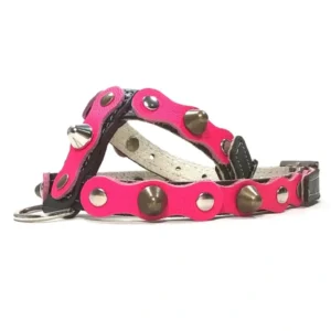 Black leather dog harness featuring a vibrant fuchsia overlay with mixed metal studs and spikes, shown from the right side. The contrast between the black base and bright fuchsia gives the harness a fierce, diva‑style attitude.