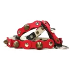 Black leather dog harness with a vivid red top layer, decorated with alternating rounded studs and sharp metal spikes, shown from the left side. The layered leather, polished hardware and intense red tone create a fierce, confident look that matches the Hot Rebel style.