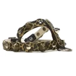 Arnés de cuero con estampado de leopardo y tachuelas sobre base negra, visto desde el lado izquierdo. El patrón salvaje crea un estilo atrevido y aventurero.