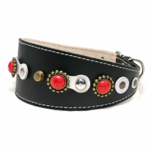 Linke Seitenansicht des Leder-Windhundhalsbands “Coral Crown” in Schwarz, verziert mit glänzenden roten Korallensteinen in einem luxuriösen, auffälligen Muster. Beschrieben für empfindliche‑Hals‑Rassen wie Dackel, Cavalier King Charles Spaniel und Beagle.