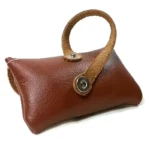 Close‑up van de achterriem en drukknoopdetails van de bruine leren houder.